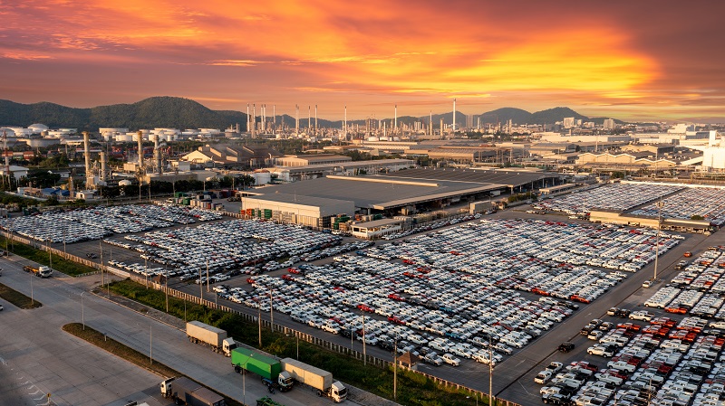Widok na fabrykę samochodów, z ogromnymi parkingami wypełnionymi samochodami